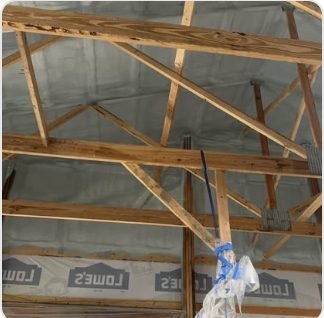 Closed-cell spray foam applied to roof trusses on a new build
